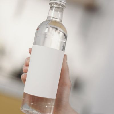 A clear water bottle resting next to a rolled-up mat.